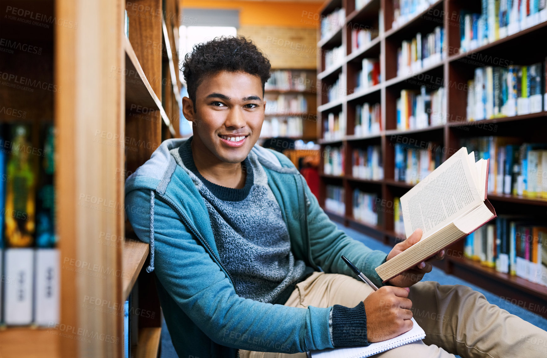 Buy stock photo Student, man and portrait with learning in library for studying, scholarship or writing in book for exam information. Education, person or happy with notebook for research notes or knowledge on floor