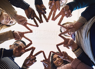 Buy stock photo Low angle portrait of a group of young friends standing in a huddle