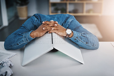 Buy stock photo Shot of a businessman lying down on a desk with a laptop over his head in an office