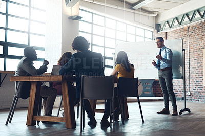 Buy stock photo Shot of a mature businessman giving a presentation to his colleagues in an office