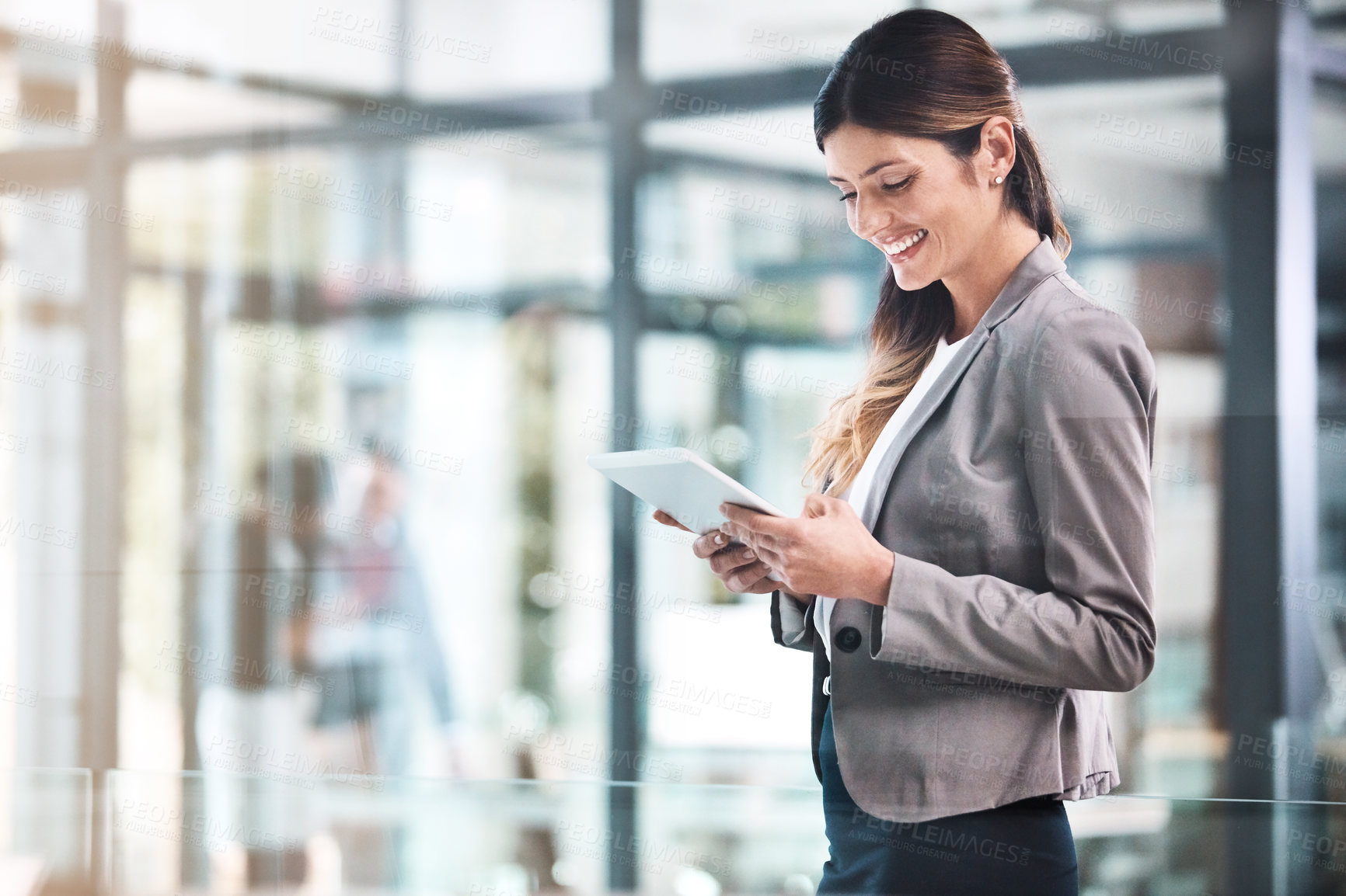 Buy stock photo Shot of a young businesswoman using a digital tablet in a modern office