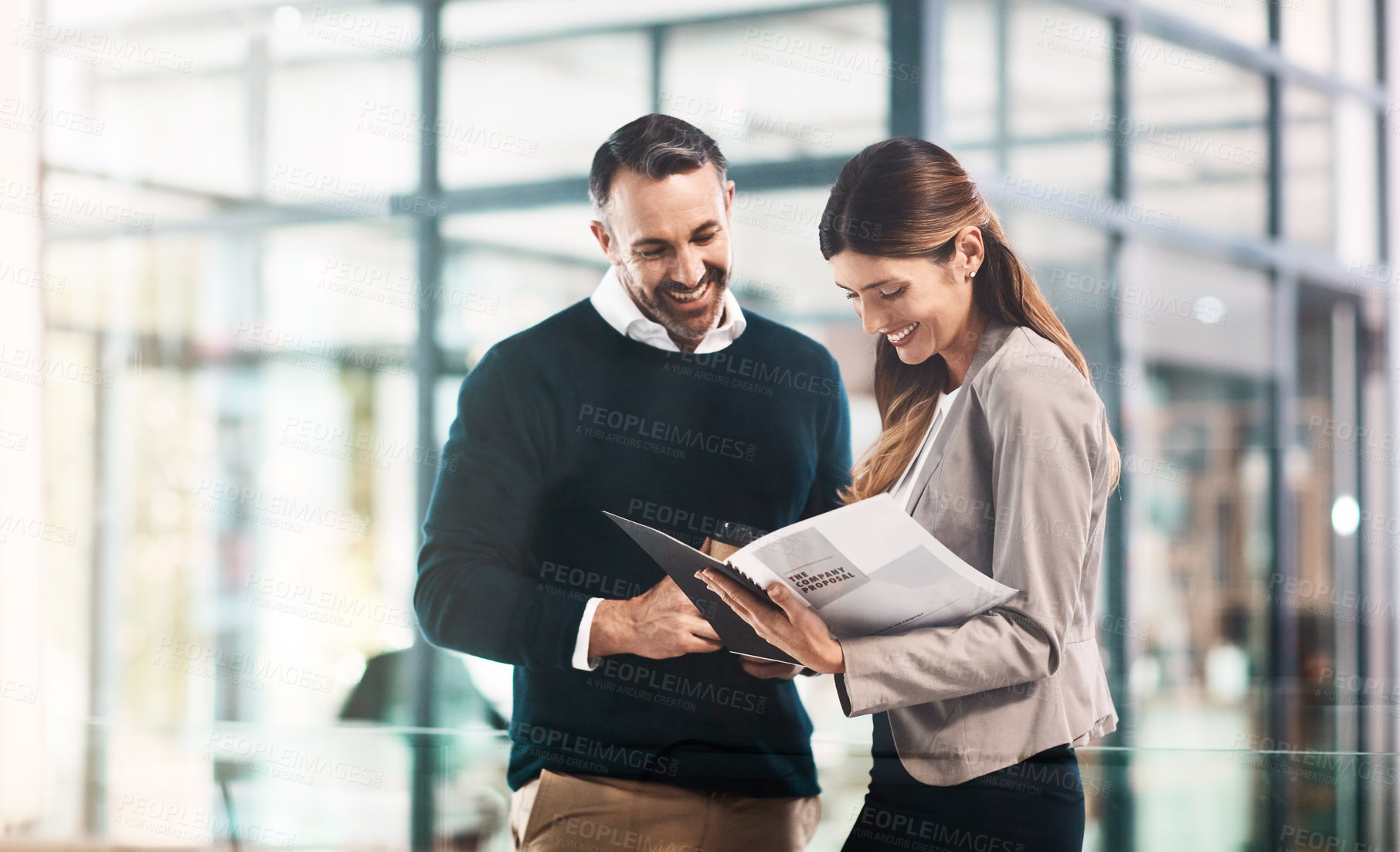 Buy stock photo Shot of a businessman and businesswoman discussing paperwork in a modern office