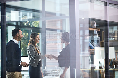Buy stock photo Shot of businesswomen shaking hands in a modern office