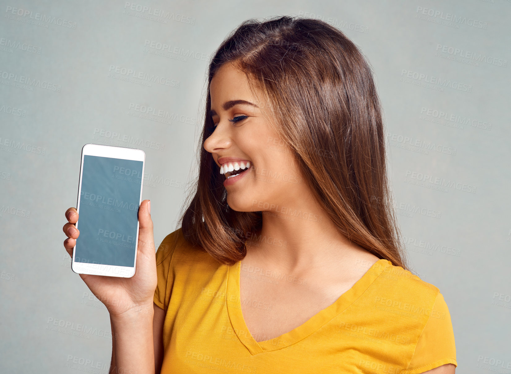 Buy stock photo Excited, woman and display of phone in studio with mockup space for advertising, marketing or promotion. Smile, technology and female person presenting cellphone screen isolated by gray background.