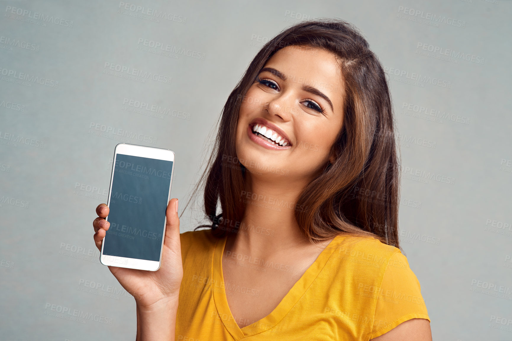 Buy stock photo Portrait, woman and display of phone screen in studio with mockup space for advertising, marketing or promotion. Smile, technology and female person presenting cellphone isolated by gray background.