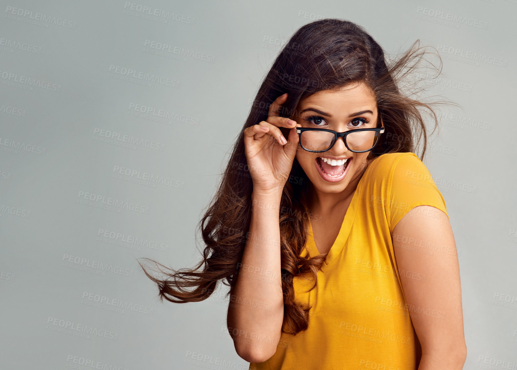 Buy stock photo Studio portrait of an attractive young woman posing against a grey background