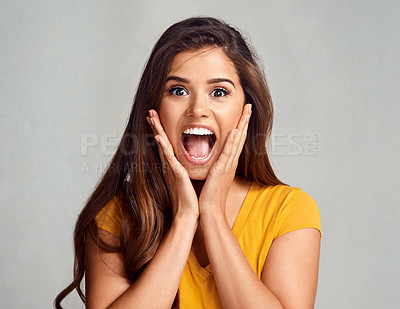 Buy stock photo Studio portrait of an attractive young woman looking surprised against a grey background