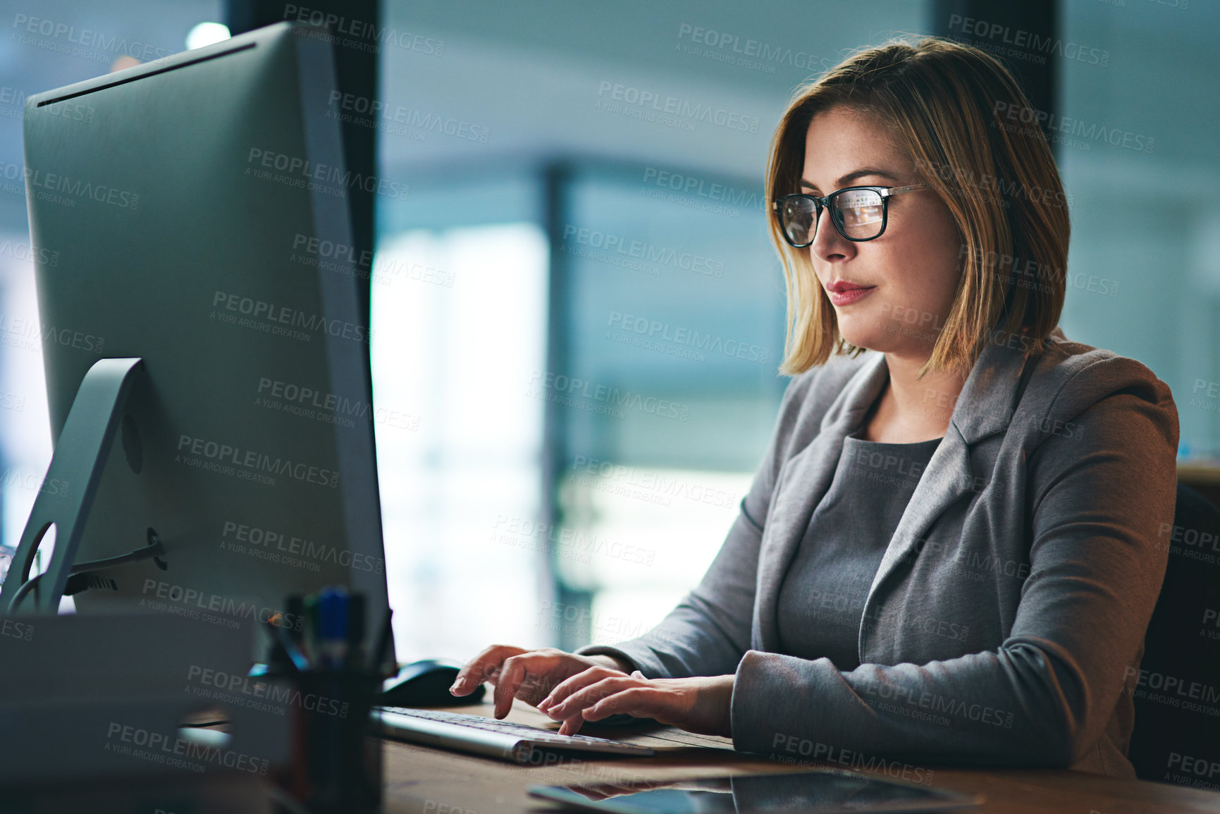 Buy stock photo Computer, business woman and typing in office, working late on project and focus at night. Desktop, professional and female person writing email, report or planning, reading and overtime for deadline