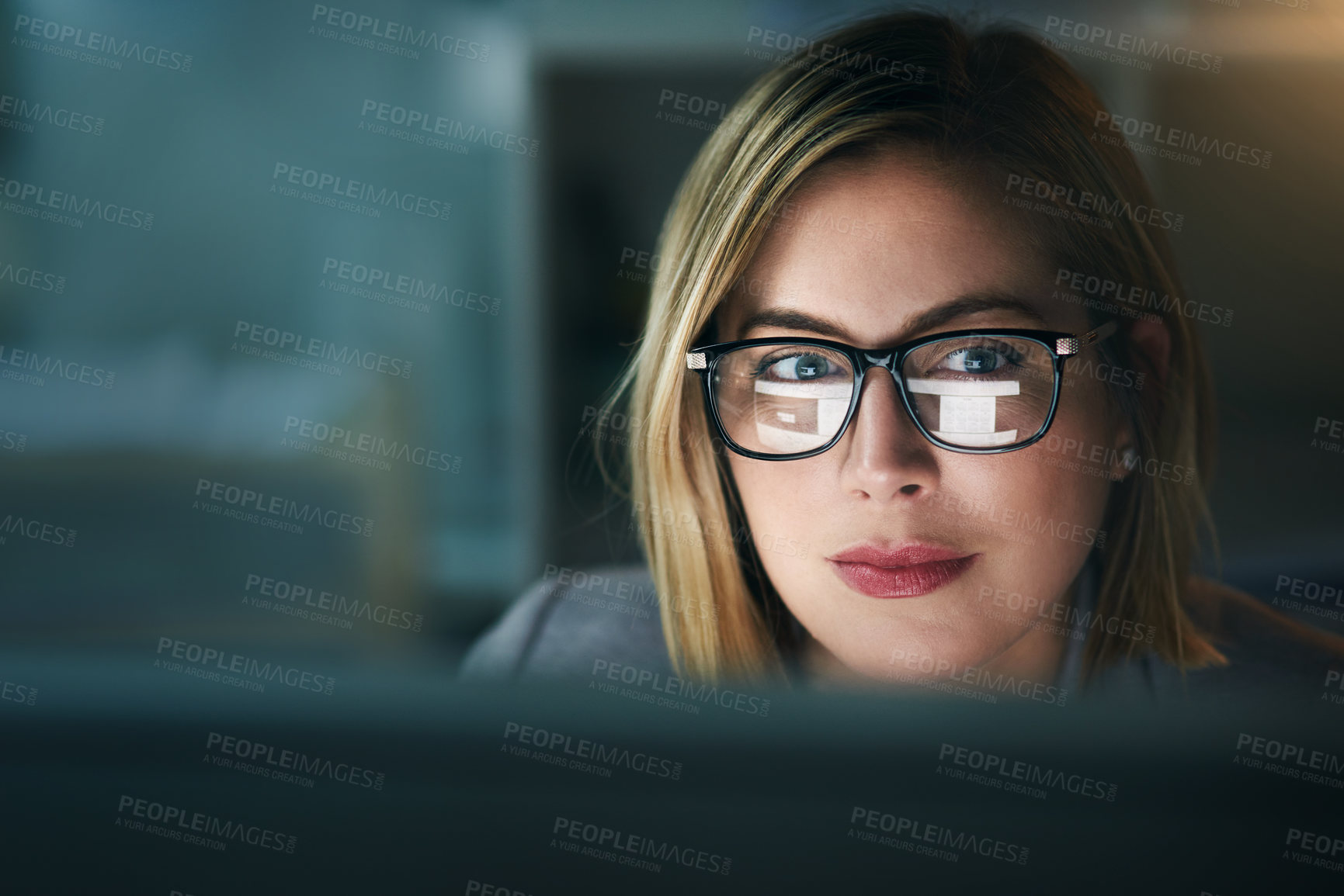 Buy stock photo Shot of a young businesswoman working late on a computer in an office