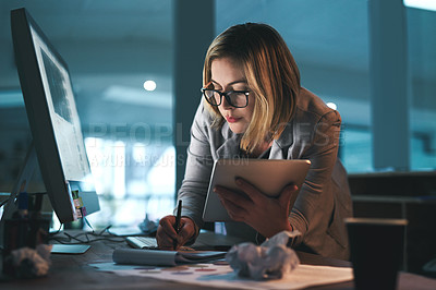 Buy stock photo Shot of a young businesswoman working late on a digital tablet in an office