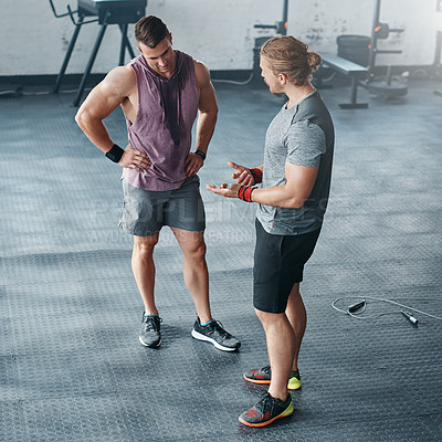 Buy stock photo Shot of two young men chatting at the gym