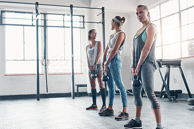 Buy stock photo Shot of three women working out with weights at the gym