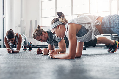 Buy stock photo Shot of an accountability group doing pushups at the gym