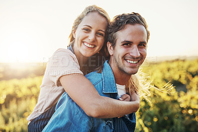 Buy stock photo Cropped portrait of a handsome young man piggybacking his girlfriend through the crops on their farm