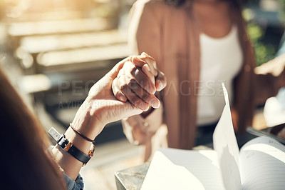 Buy stock photo Cropped shot of a group of creative employees holding hands and praying before breakfast outdoors