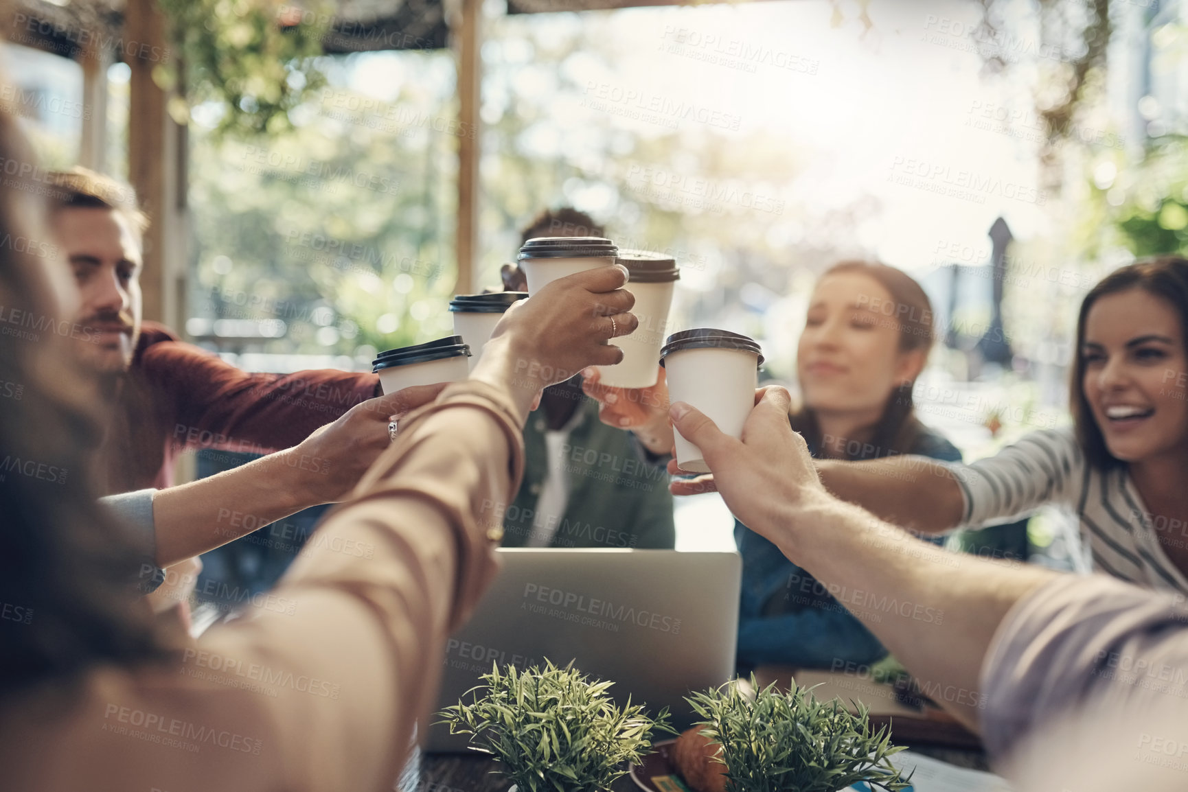 Buy stock photo Business people, hands and cheers with coffee for meeting, team building or discussion at outdoor cafe. Young group of creative employees toasting with beverage for startup together at restaurant