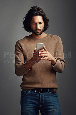 Buy stock photo Communication, man and using phone in studio for reading, blog and online for mobile app. Streaming, male model and social media or internet for networking, connection and typing by dark background