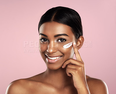 Buy stock photo Happy, skincare and face of woman with cream in studio isolated on a pink background. Dermatology, creme cosmetics and portrait of happy Indian female model apply moisturizer lotion for healthy skin.