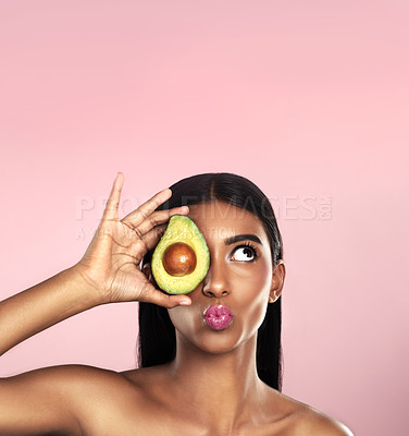 Buy stock photo Studio shot of a beautiful young woman posing with an avocado against a pink background