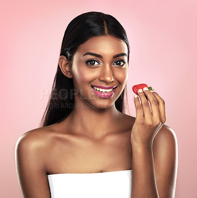 Buy stock photo Portrait, girl or glow of eating, fruit or nutrition, idea or wellness as health on studio mockup. Indian woman, strawberry or smile at planning, weight loss or antioxidant, detox or pink background