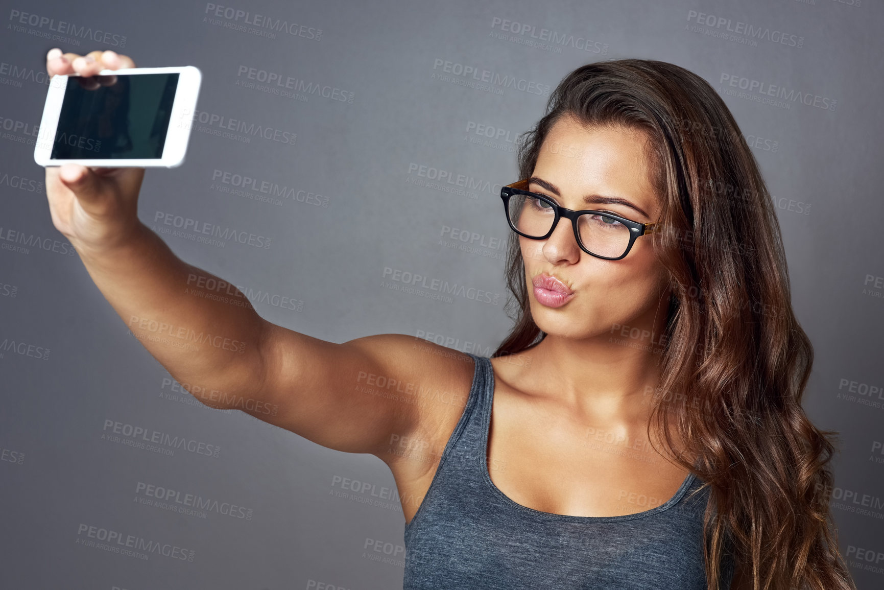 Buy stock photo Glasses, pouting and selfie with influencer woman in studio for social media status post or update. Eyewear, kissing and photograph with confident model on gray background for profile picture