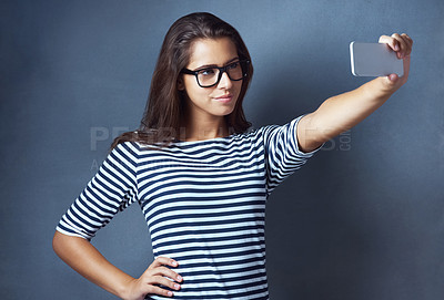 Buy stock photo Girl, studio and smile with eyeglasses on selfie on grey background for eyesight and eyewear prescription. Woman, satisfied and confident with social media post, profile picture and frame or vision