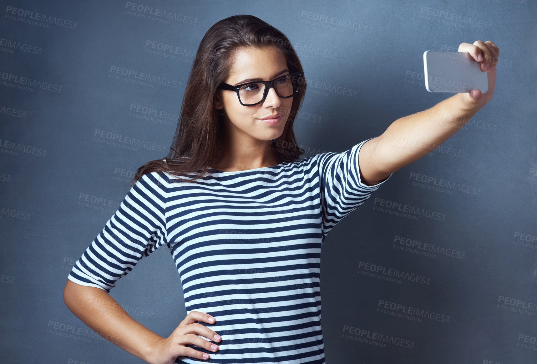 Buy stock photo Girl, studio and smile with eyeglasses on selfie on grey background for eyesight and eyewear prescription. Woman, satisfied and confident with social media post, profile picture and frame or vision