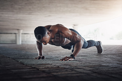Buy stock photo Full length shot of a handsome young man doing pushups while exercising outside