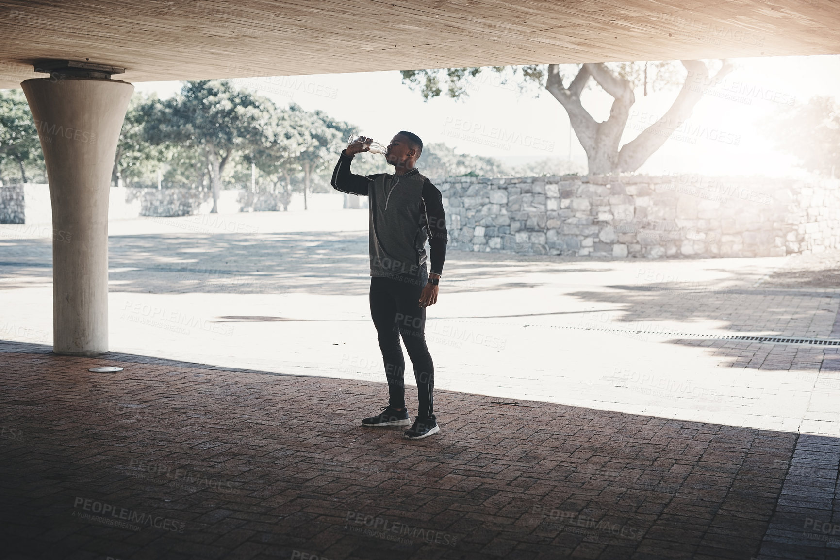 Buy stock photo Black man, athlete and drinking water for exercise health or hydration for electrolytes, training or park. Male person, bottle and city street for healthy performance or running break, outdoor or fit