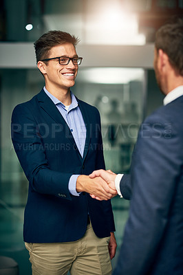 Buy stock photo Cropped shot of two handsome businessmen shaking hands in an office