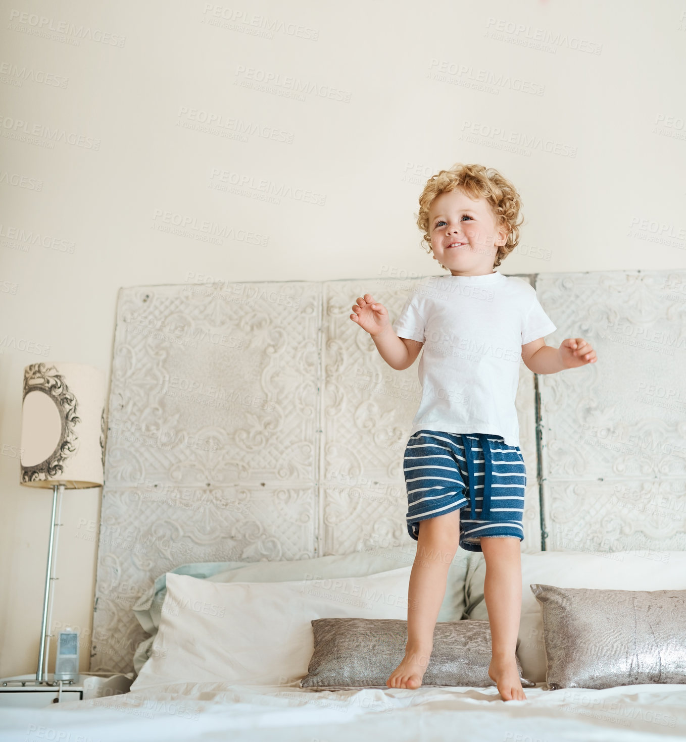 Buy stock photo Happy, child and jump on bed for fun with energy, coordination balance and muscle development of activity. Excited, boy and play game in air for gross motor skills, kinesthetic learning and house