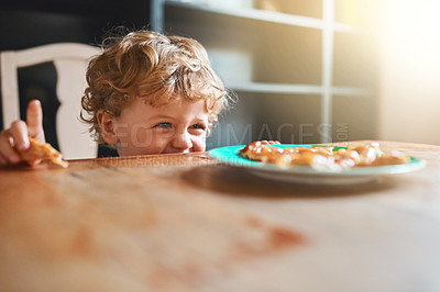 Buy stock photo Cropped shot of an adorable little boy eating at home