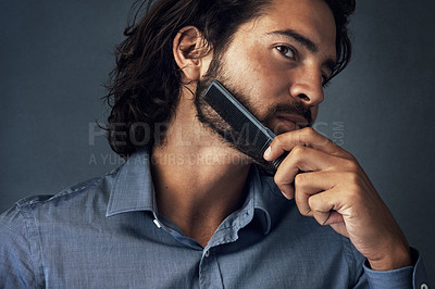 Buy stock photo Handsome man, fashion and haircare with comb for grooming, morning or routine on a gray studio background. Male person, employee or model with brush for beard maintenance or facial hair treatment