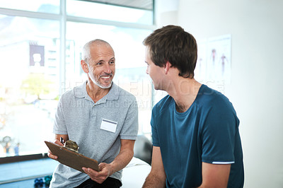 Buy stock photo Cropped shot of a handsome mature male physiotherapist having a consultation with a patient