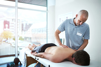 Buy stock photo Cropped shot of a handsome mature male physiotherapist treating a patient