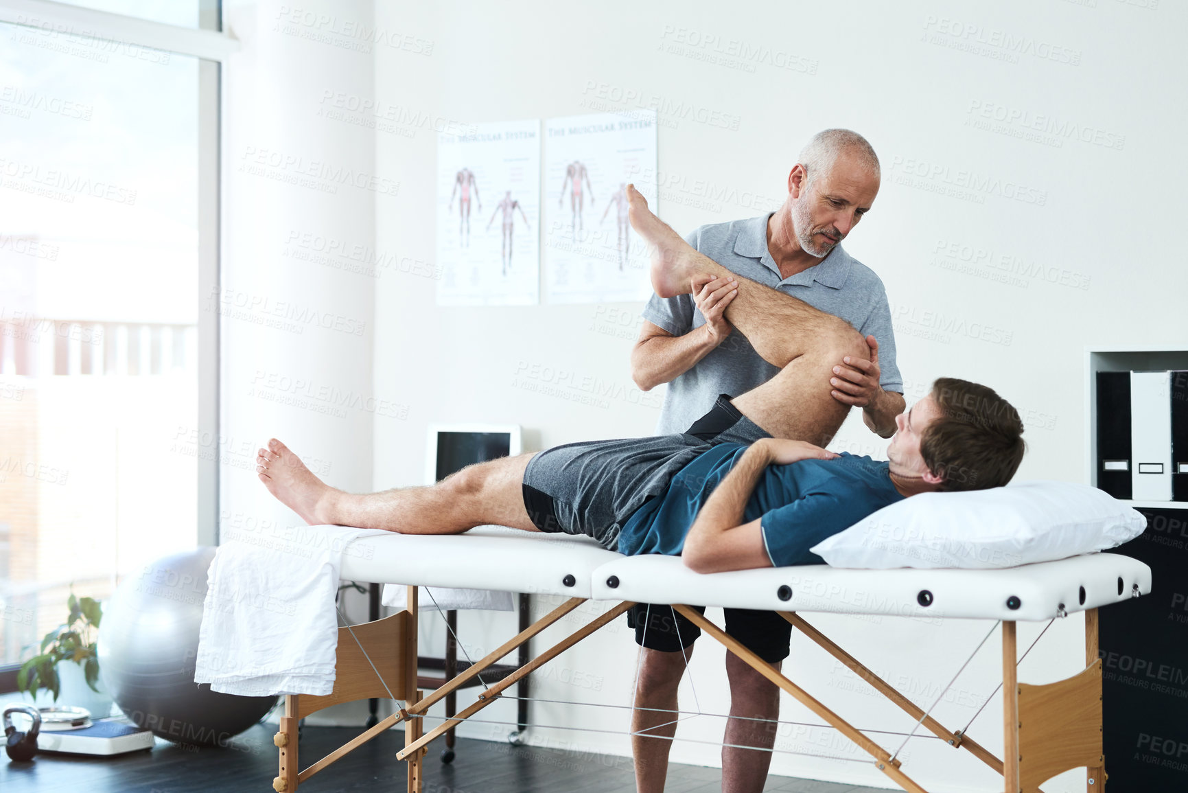 Buy stock photo Man, knee pain and physiotherapist stretching in consulting, rehabilitation with exercise for wellness. Male people, office or together for physiotherapy service with health insurance or support