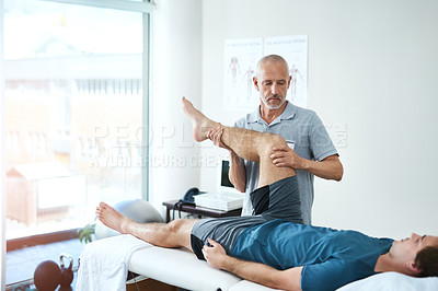 Buy stock photo Legs, physiotherapist and patient with consultation, healthcare and stretching for recovery. Male person, men and chiropractor with a client, physical therapy and healing with rehabilitation and care