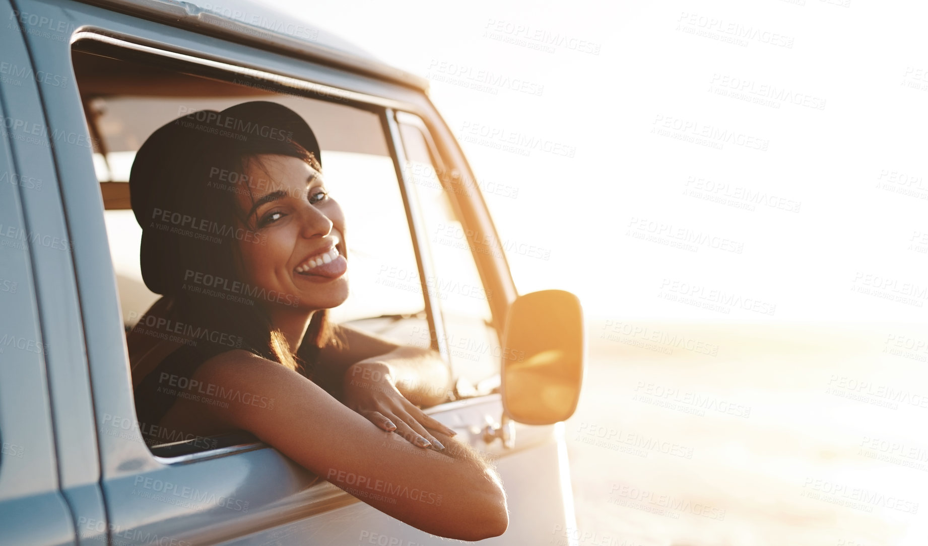 Buy stock photo Woman, portrait and happy in van for road trip, sunset and adventure in summer with hat or flare. Female person, smile and car for travel, dusk and journey outdoor with tongue out, freedom and drive