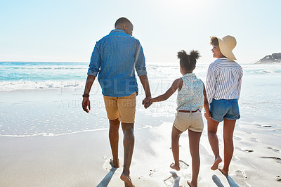 Buy stock photo Shot of an adorable little girl going for a walk with her parents on the beach