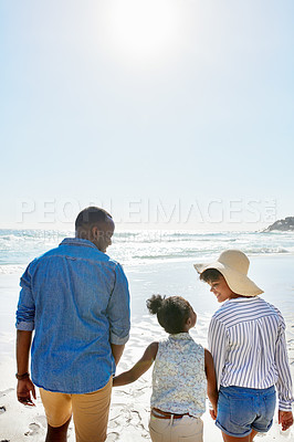 Buy stock photo Black family, back and holding hands with kid on beach for bonding, holiday or outdoor weekend. African mother, father and child walking in sunshine together for fun summer by ocean coast in nature