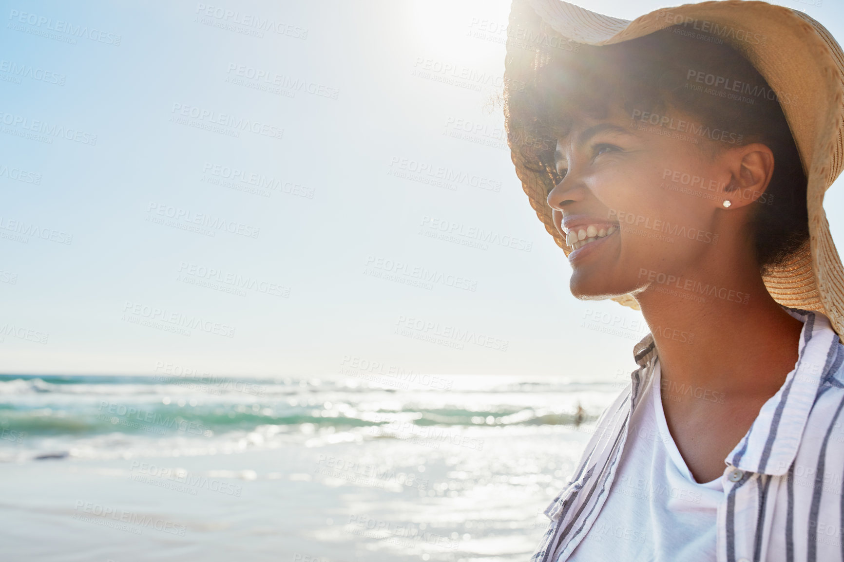 Buy stock photo Shot of a young woman enjoying a day at the beach