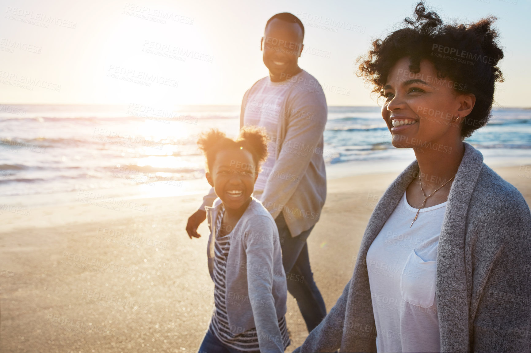 Buy stock photo Shot of an adorable little girl going for a walk with her parents on the beach