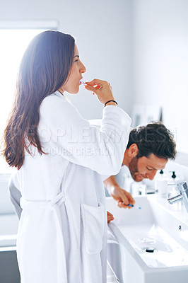 Buy stock photo Cropped shot of a couple brushing their teeth in the bathroom at home together