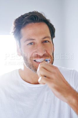 Buy stock photo Cropped shot of a handsome middle aged man brushing his teeth in the bathroom at home
