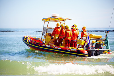 Buy stock photo Full length shot of a group of lifeguards heading out  to sea on a rescue mission