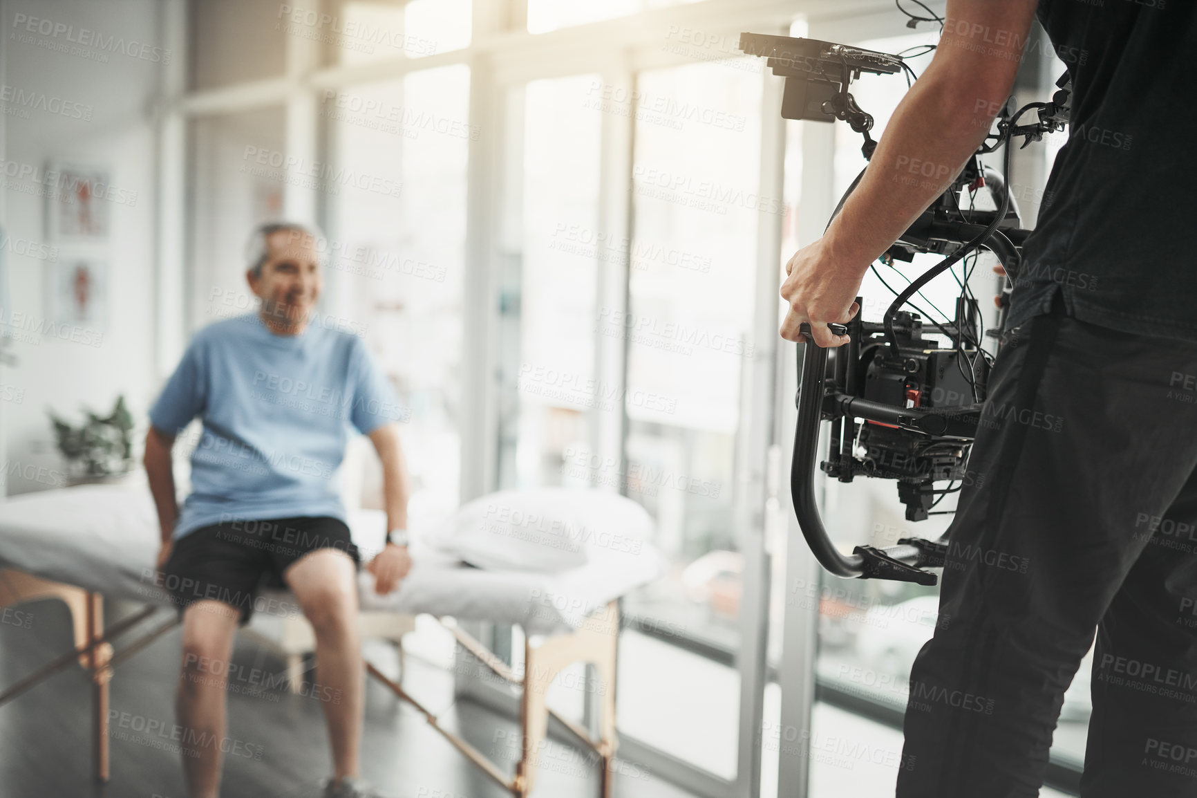 Buy stock photo Behind the scenes shot of an unrecognizable camera operator shooting a scene with a state of the art camera inside of a studio during the day
