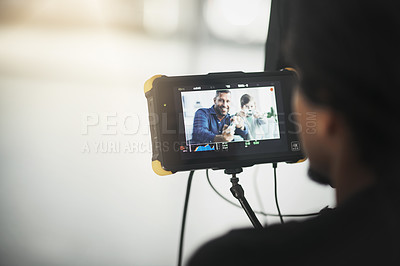 Buy stock photo Behind the scenes over the shoulder shot of an unrecognizable person operating a state of the art video camera inside of a studio