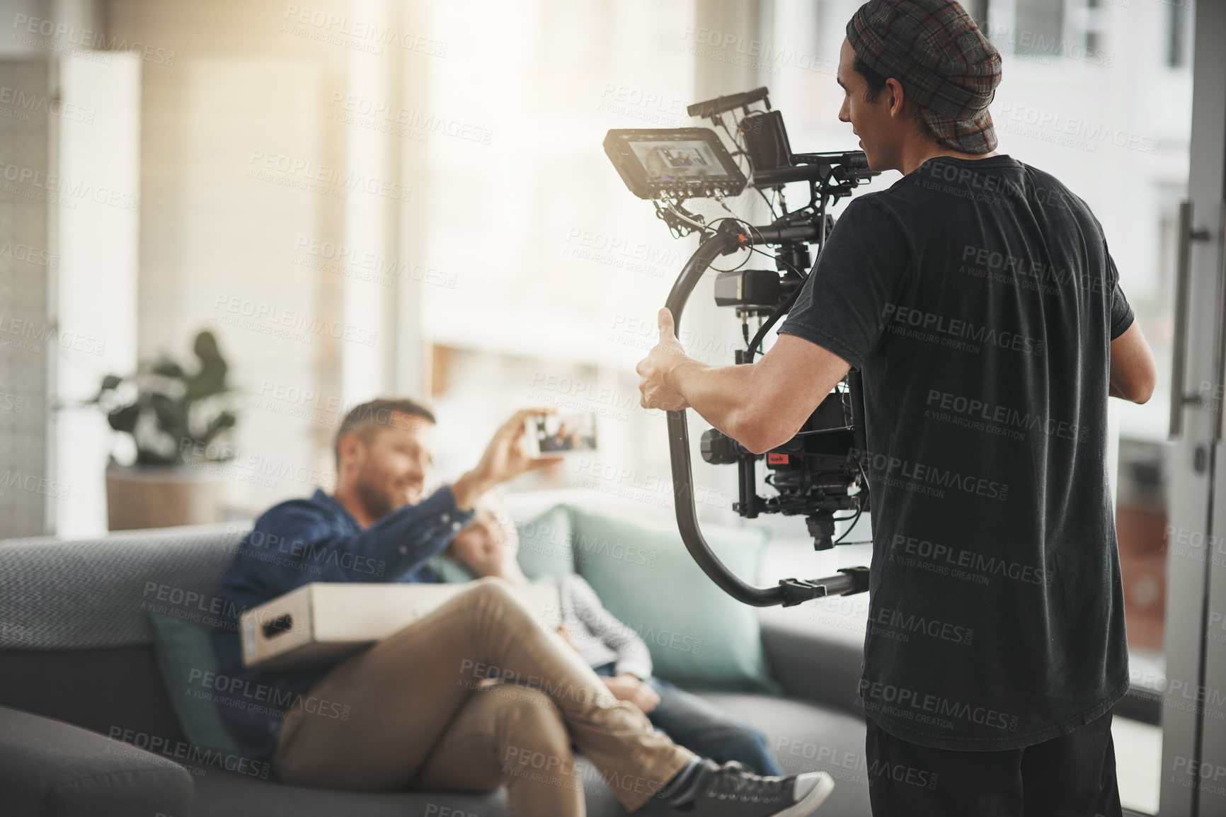 Buy stock photo Cameraman, technology and model in film or media production for shooting, script or brief in studio. Male people, equipment and behind the scenes as videographer for cinema, broadcast or advertising