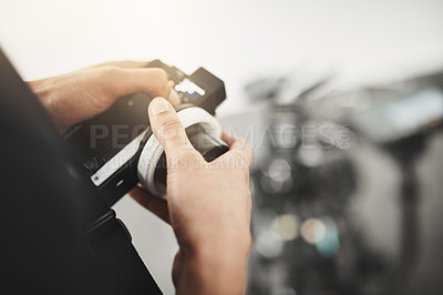 Buy stock photo Behind the scenes over the shoulder shot of an unrecognizable person operating state of the art video camera equipment inside of a studio