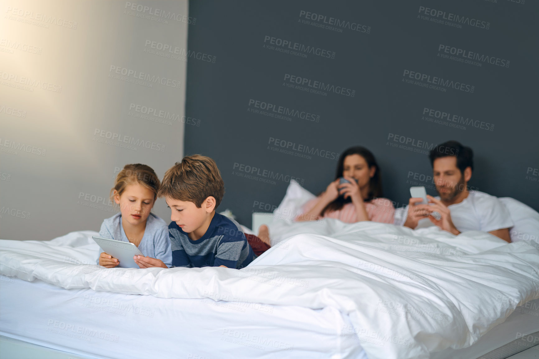 Buy stock photo Tablet, relax and children with parents in bed playing online educational game for learning. Rest, digital technology and kids watching video for entertainment with mom and dad in bedroom at home.